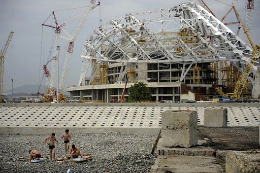 Workers take a break near the 'Fisht' Olympic stadium, which is under construction for the Sochi 2014 Winter Olympics